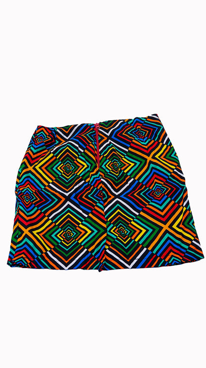 "Minifalda sastrera estructurada confeccionada con auténtica tela africana Ankara, presentando un vibrante patrón geométrico de cuadrados concéntricos en capas de colores rojo, amarillo, verde, azul y negro. La falda tiene tiro alto, cierre posterior central de cremallera roja visible y corte evasé. capturada contra un fondo blanco limpio